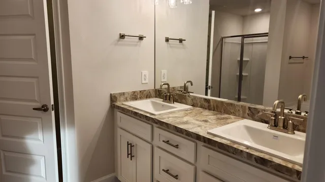 a bathroom with a granite countertop sink and a mirror
