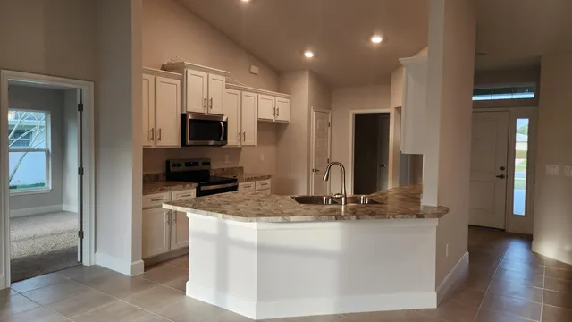 a kitchen with stainless steel appliances granite countertop a refrigerator and a sink
