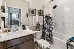 a bathroom with a sink a toilet and shower curtain