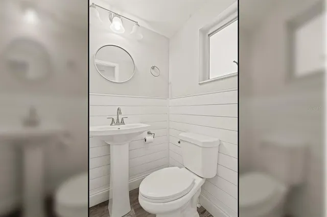 a bathroom with a toilet a sink and mirror