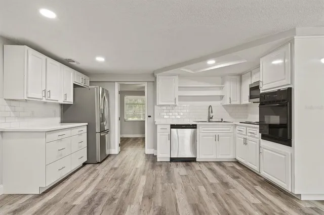a kitchen with white cabinets and white appliances