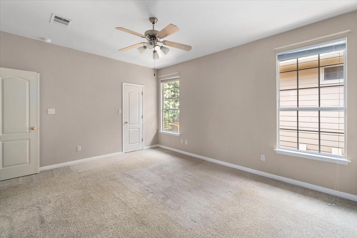 11000 Anderson Mill Road, Unit 11 Austin, TX 78750 - Photo 13 of 34 A well-proportioned bedroom features soft carpeting, ample light from multiple windows, and a convenient ceiling fan.