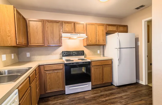 a kitchen with a white stove and refrigerator
