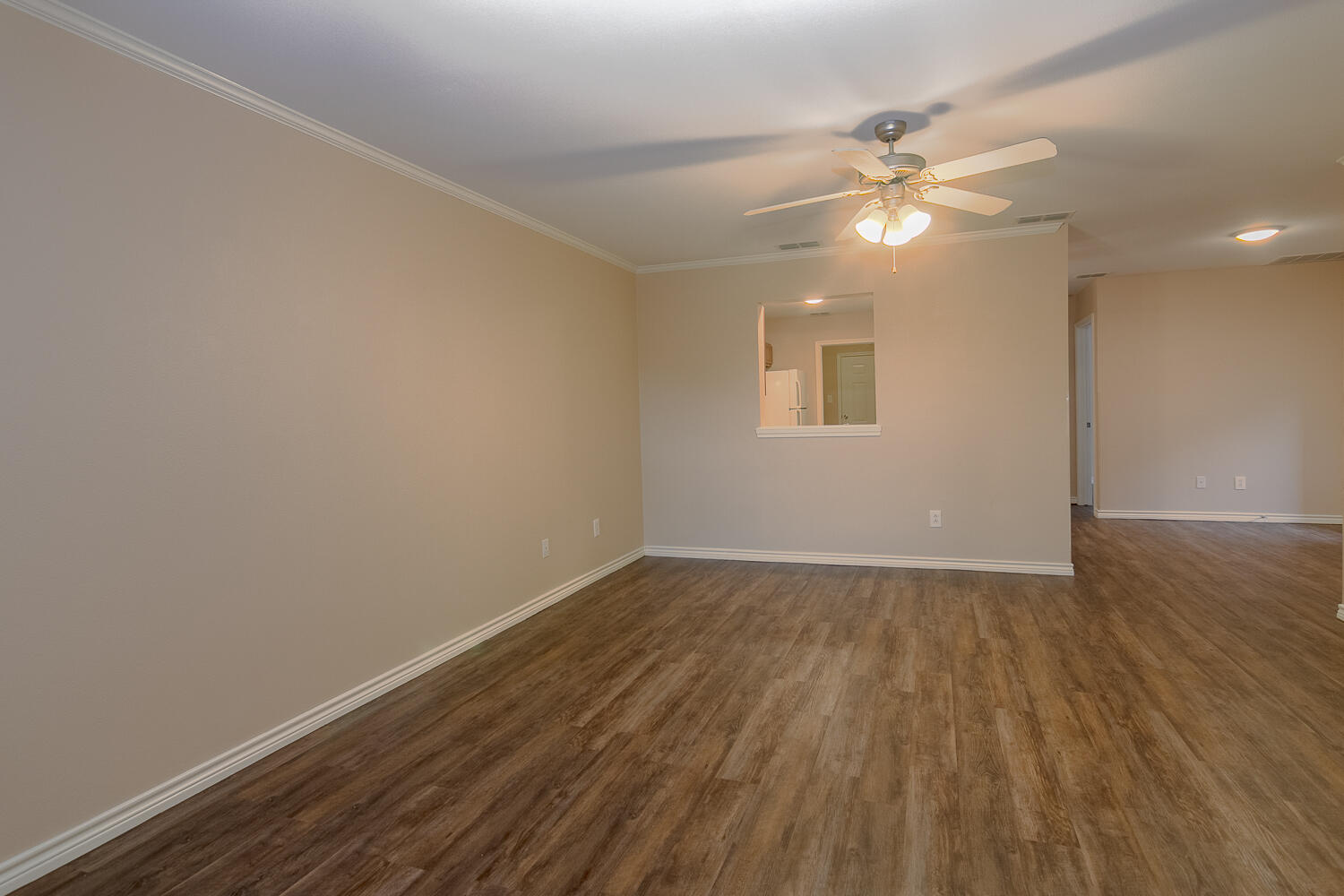 505 North Chicago Avenue, Unit B Lubbock, TX 79416 - Photo 4 of 12 an empty room with wooden floor and fan
