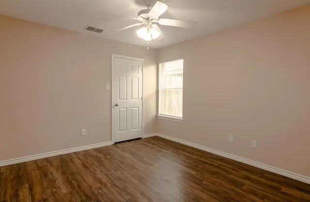 wooden floor in an empty room with a window