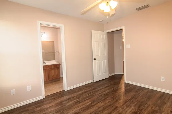 an empty room with wooden floor and a bathroom