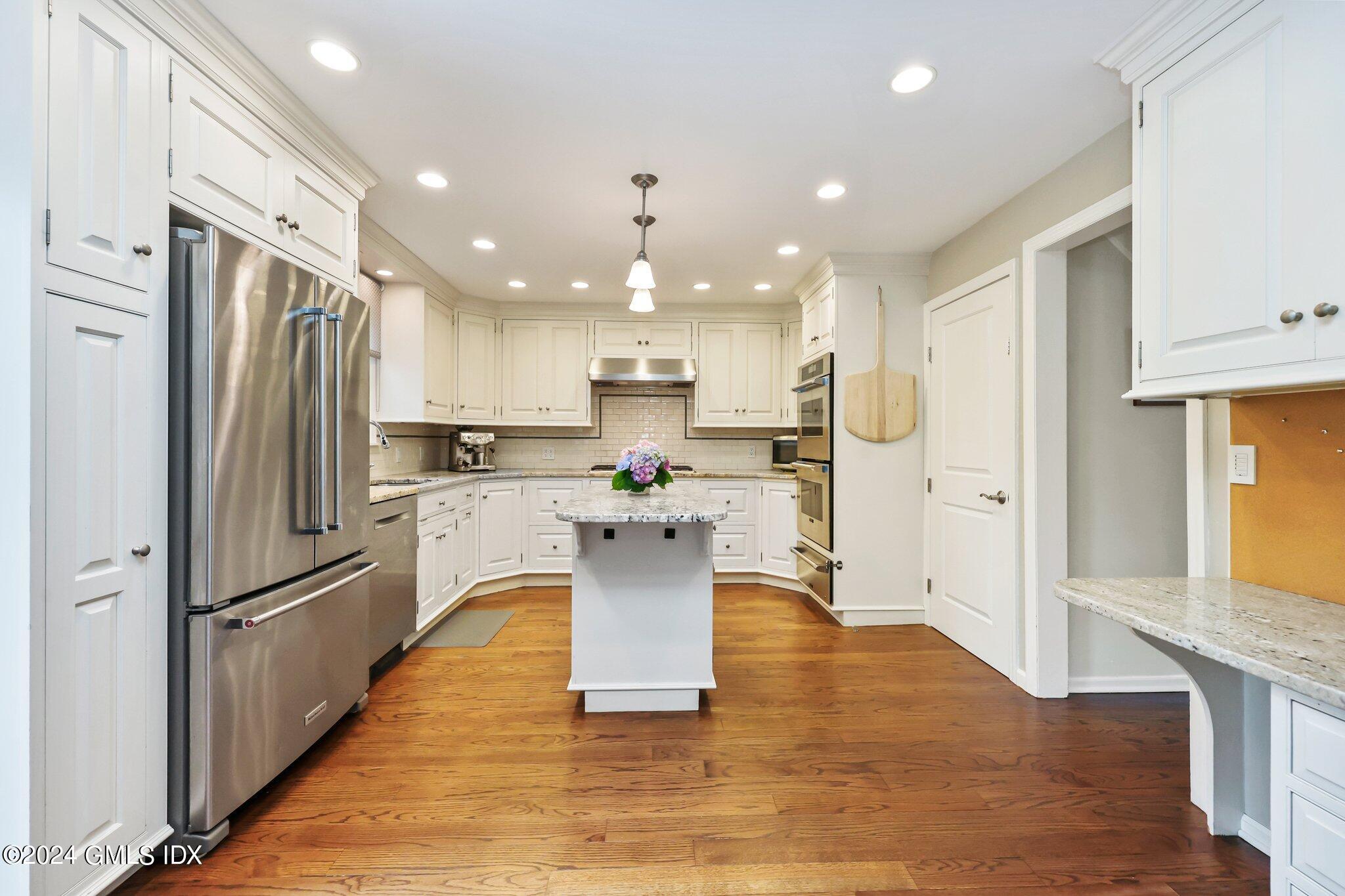 138 Byram Road, Unit 1 Greenwich, CT 06830 - Photo 13 of 36 a kitchen with kitchen island white cabinets stainless steel appliances and a refrigerator