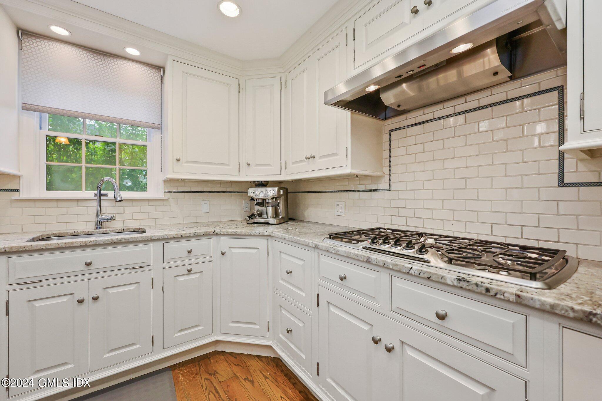 138 Byram Road, Unit 1 Greenwich, CT 06830 - Photo 15 of 36 a kitchen with granite countertop white cabinets stainless steel appliances a sink and a window