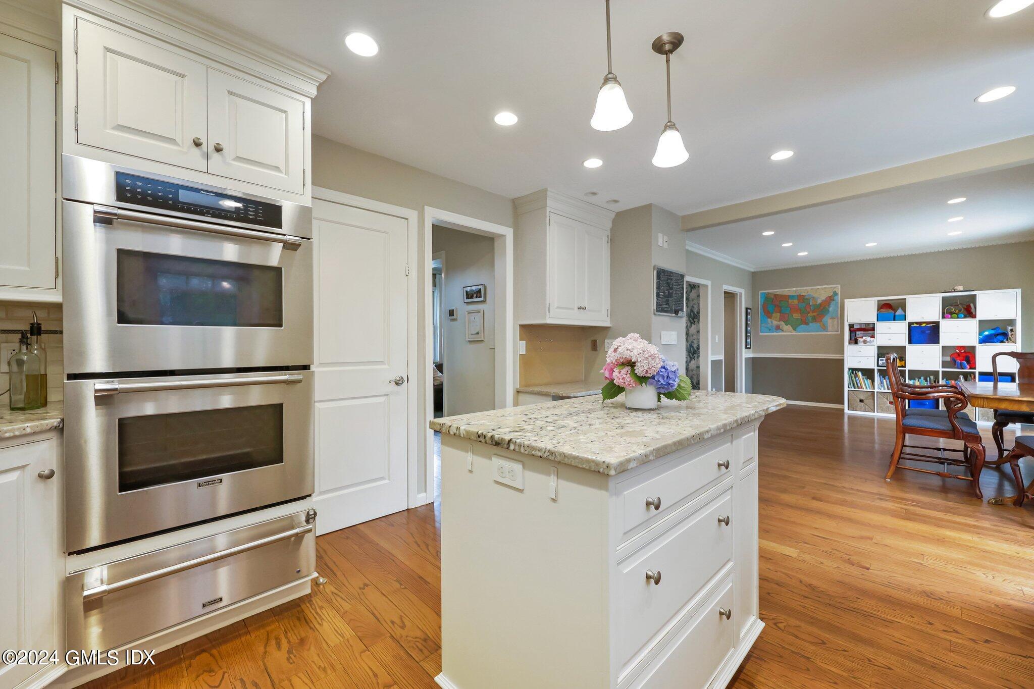 138 Byram Road, Unit 1 Greenwich, CT 06830 - Photo 16 of 36 a kitchen with stainless steel appliances kitchen island granite countertop a stove top oven a sink dishwasher a dining table and chairs with wooden floor