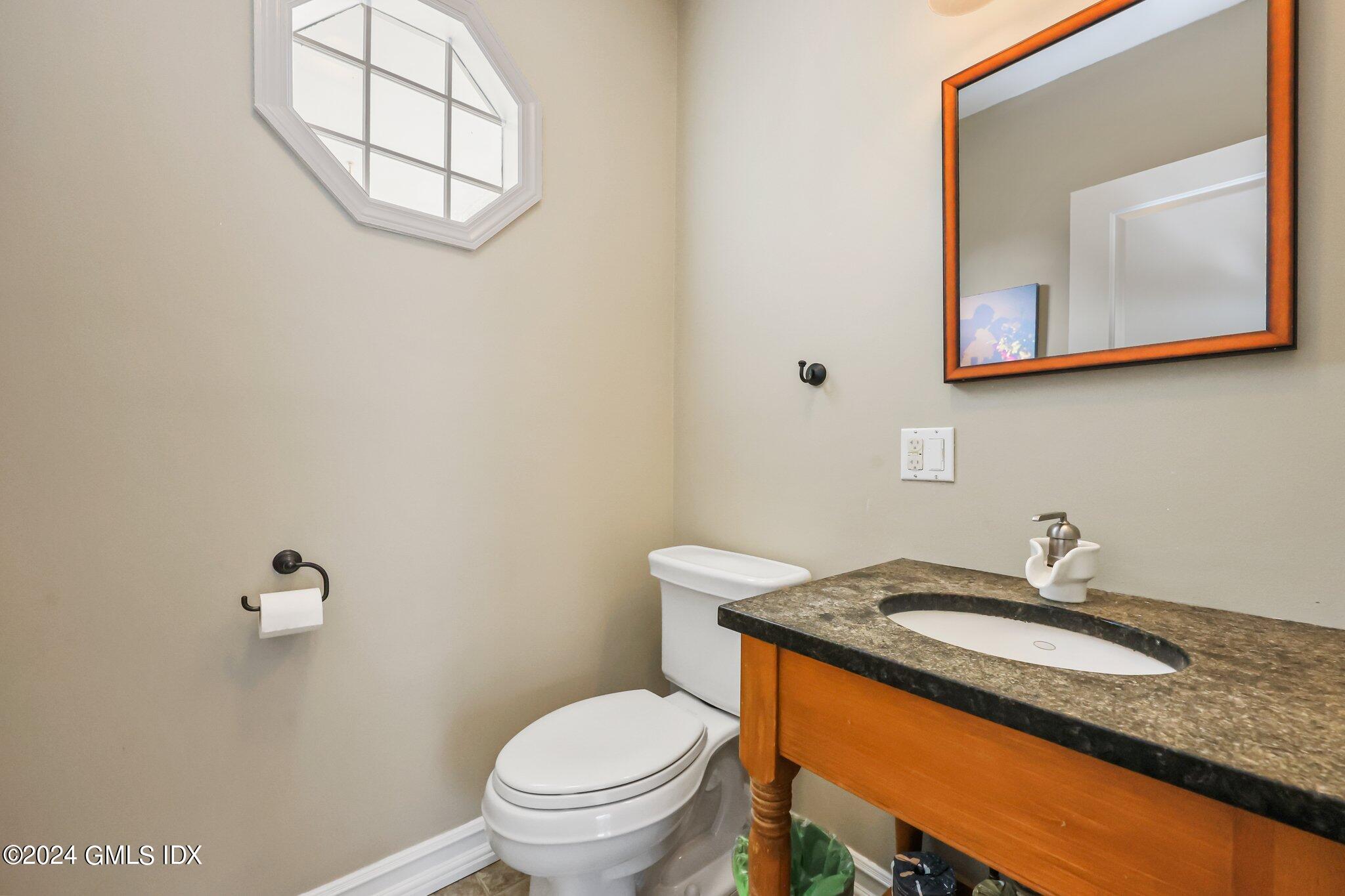 138 Byram Road, Unit 1 Greenwich, CT 06830 - Photo 19 of 36 a bathroom with a granite countertop sink mirror vanity and toilet