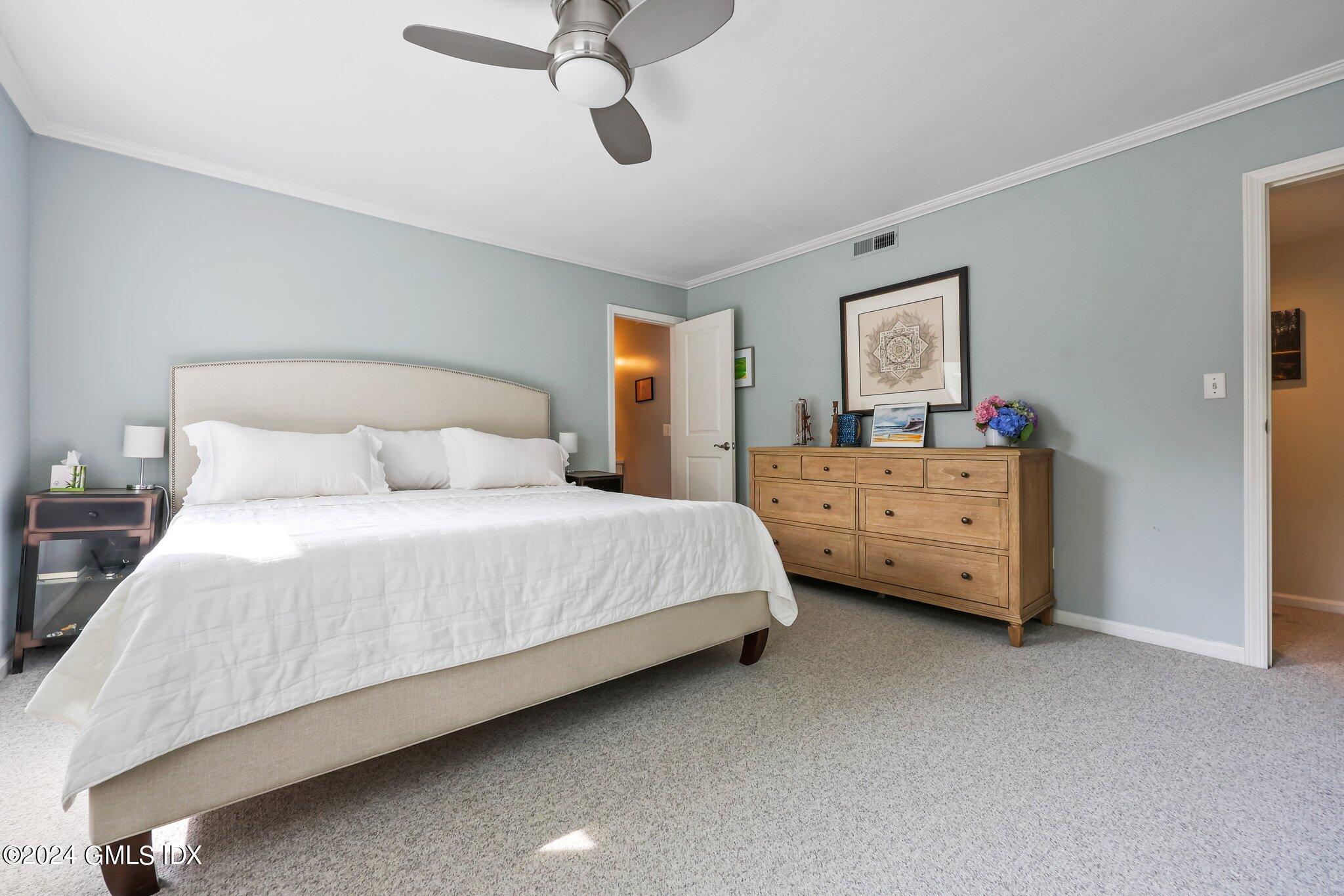 138 Byram Road, Unit 1 Greenwich, CT 06830 - Photo 21 of 36 a bedroom with a bed and a chandelier