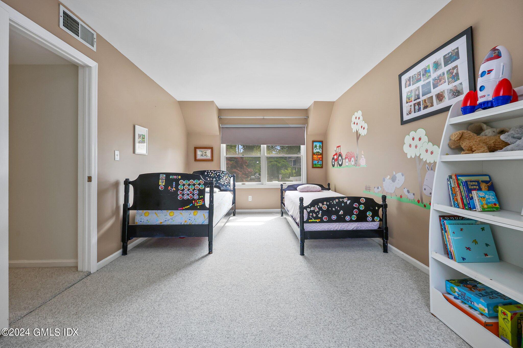 138 Byram Road, Unit 1 Greenwich, CT 06830 - Photo 23 of 36 a bedroom with furniture and a book shelf