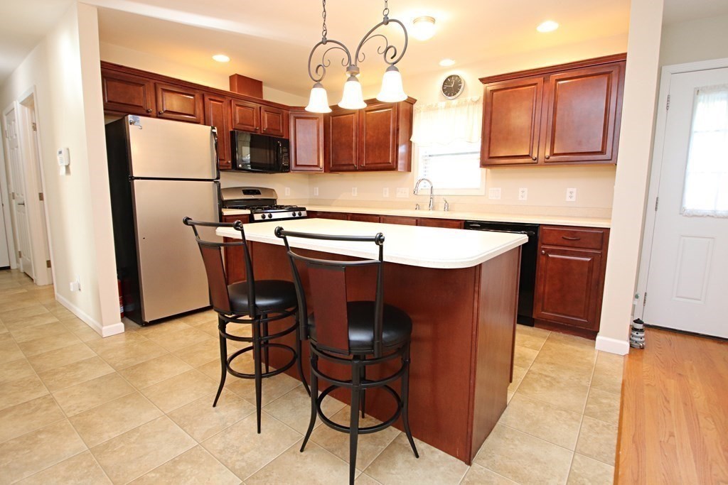 10 Pace Road Saugus, MA 01906 - Photo 6 of 42 a kitchen with stainless steel appliances granite countertop a table chairs and a refrigerator
