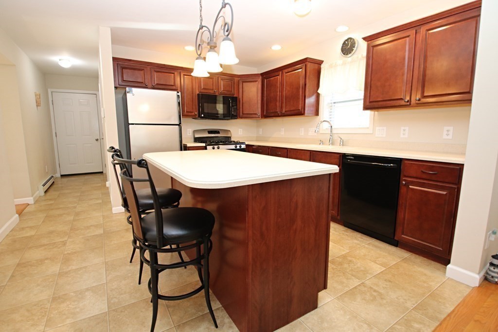 10 Pace Road Saugus, MA 01906 - Photo 8 of 42 a kitchen with kitchen island a sink table and chairs