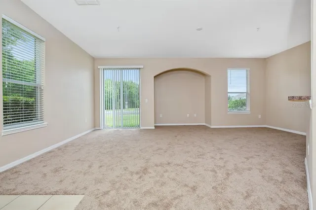 a view of a big room with windows and chandelier fan