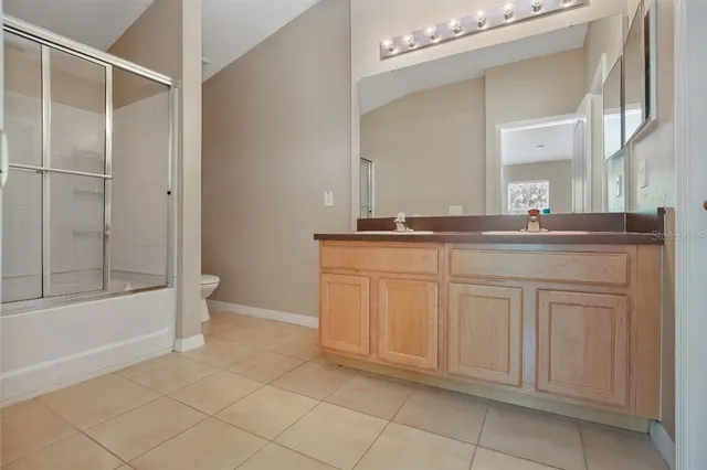 a spacious bathroom with a granite countertop sink a mirror and a bathtub