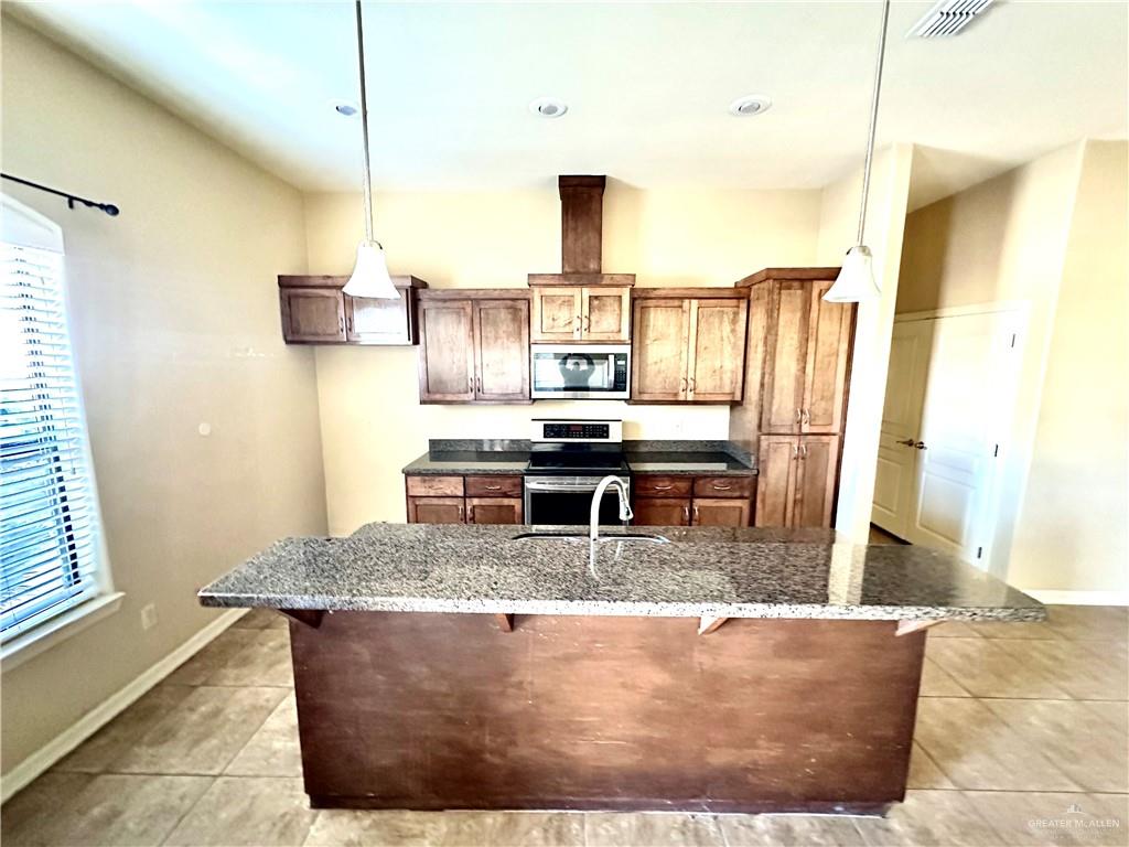 2715 Mimosa Street, Unit 3 Mission, TX 78574 - Photo 6 of 13 a kitchen with kitchen island granite countertop a sink a counter top space and stainless steel appliances