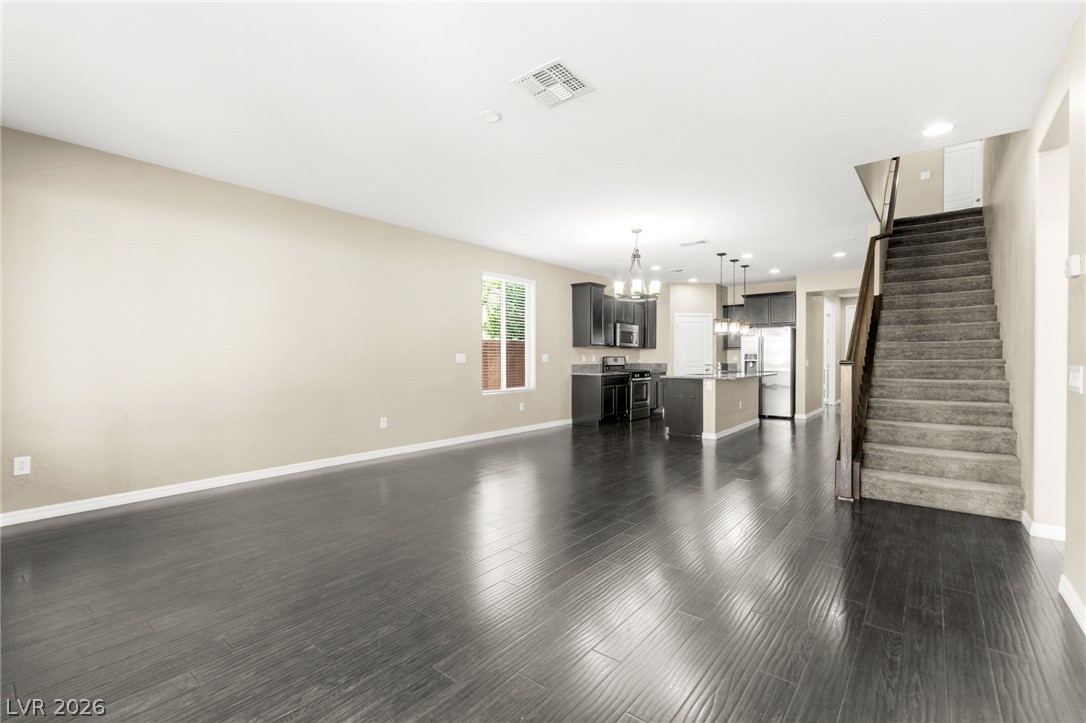 11048 Prairie Grove Road Las Vegas, NV 89179 - Photo 74 of 75 An open floorplan seamlessly connects the living space to a well-appointed kitchen and convenient staircase access.