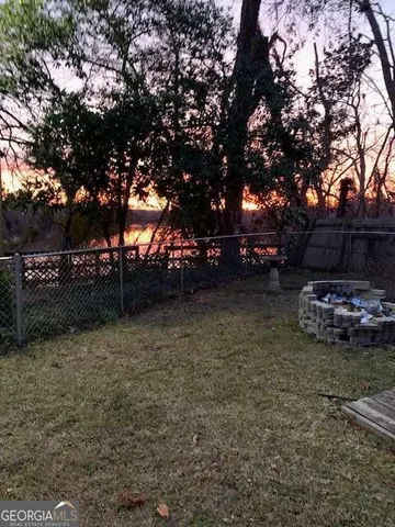 a view of a patio with table and chairs potted plants with wooden floor and fence