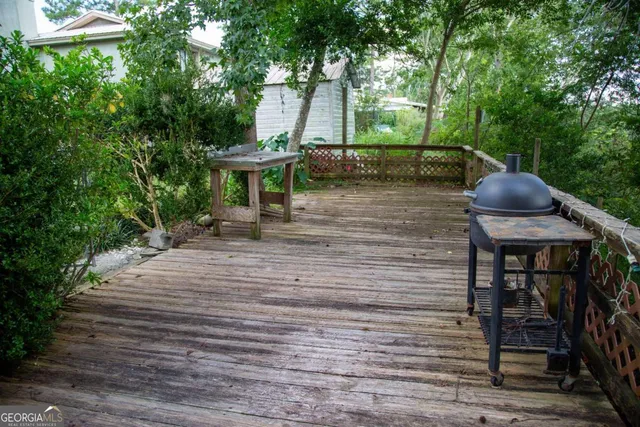 a view of a wooden bench with plants in front of it