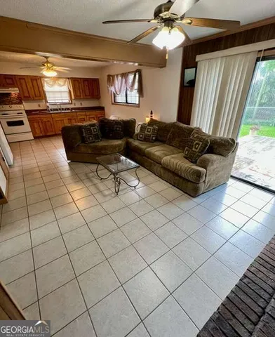 a living room with a couch and a dining table with wooden floor