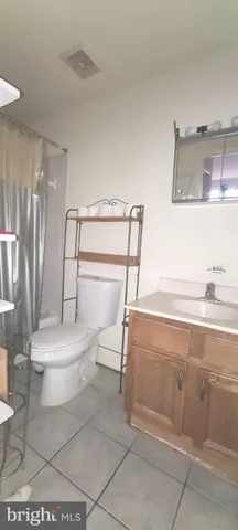 a white toilet sitting next to a bathroom sink and a shower