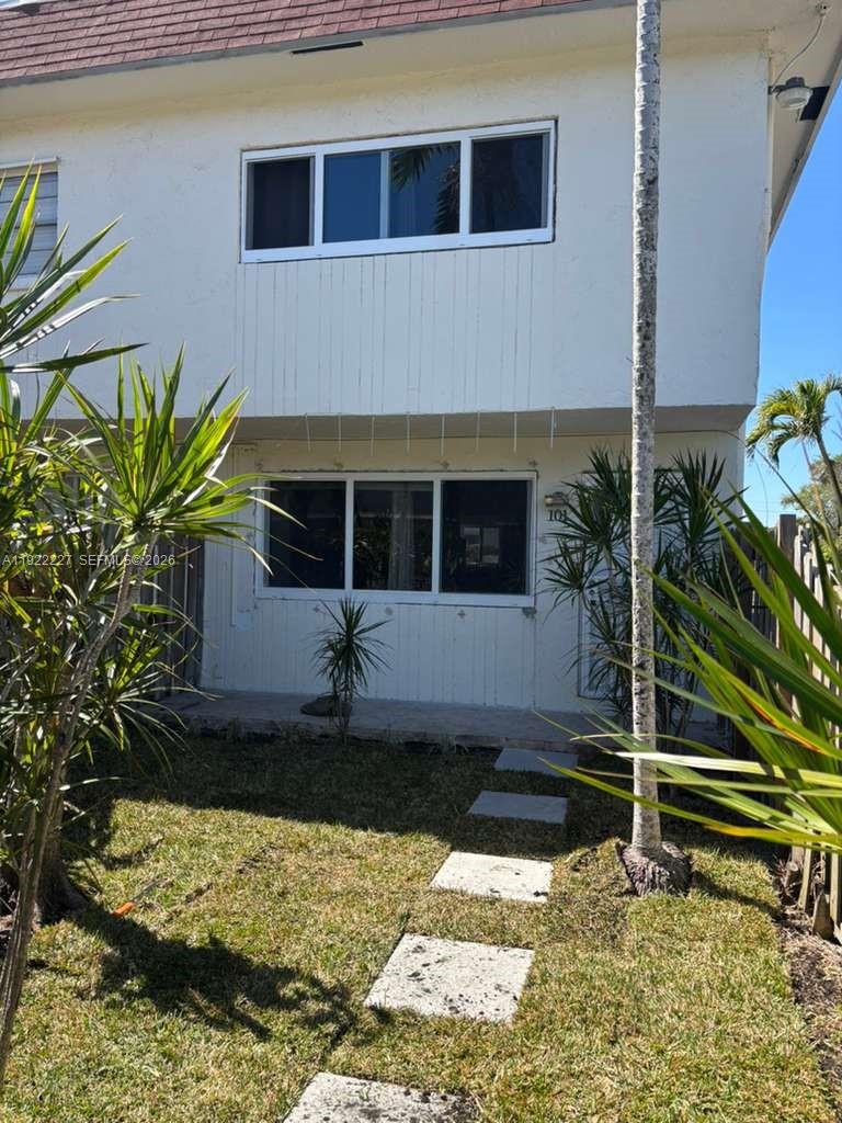 1480 Northeast 151st Street, Unit 101 Miami, FL 33162 - Photo 1 of 26 a house with trees in front of it