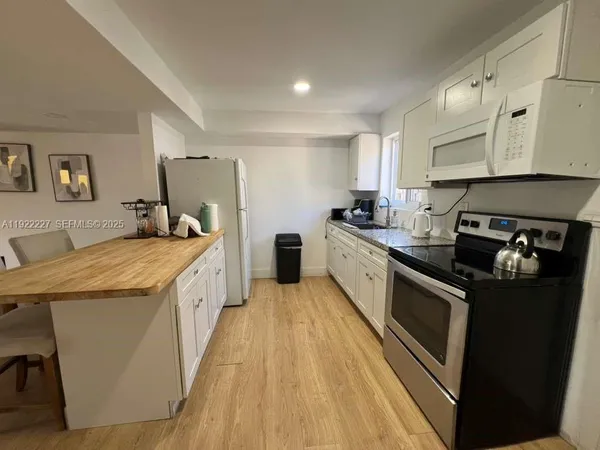 a kitchen with stainless steel appliances granite countertop a lot of counter space and wooden floors