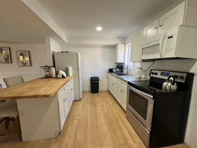 a kitchen with stainless steel appliances granite countertop a lot of counter space and wooden floors