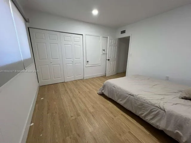a spacious bedroom with a bed and a dresser