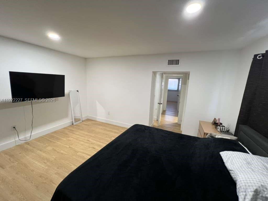 1480 Northeast 151st Street, Unit 101 Miami, FL 33162 - Photo 19 of 26 a bedroom with a bed and a flat screen tv