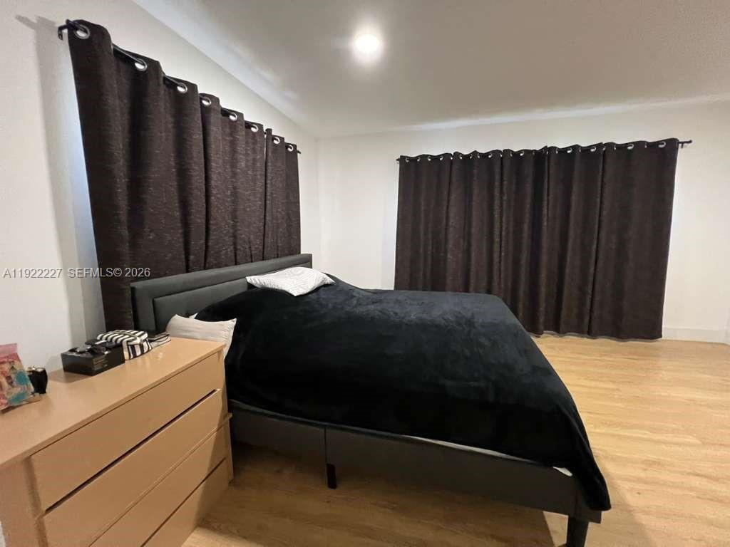 1480 Northeast 151st Street, Unit 101 Miami, FL 33162 - Photo 20 of 26 a bedroom with a bed and a dresser