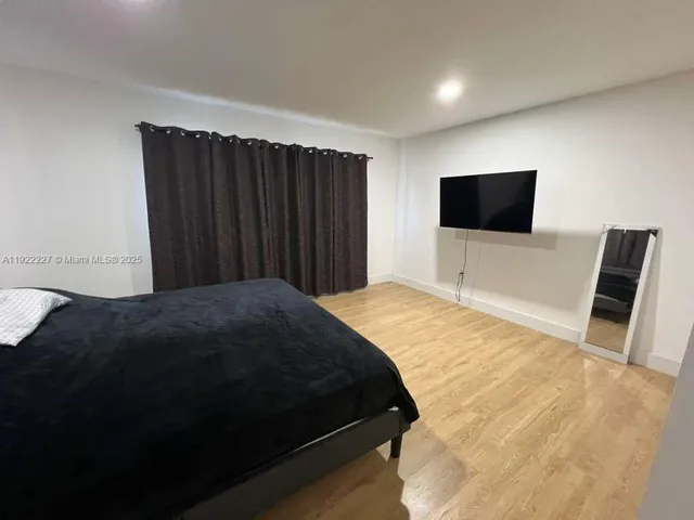 a bedroom with a bed and a flat screen tv