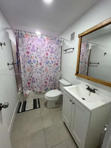 a bathroom with a sink mirror vanity and toilet