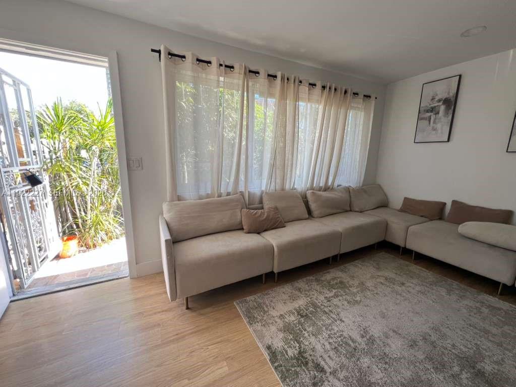 1480 Northeast 151st Street, Unit 101 Miami, FL 33162 - Photo 3 of 26 a living room with furniture and a large window