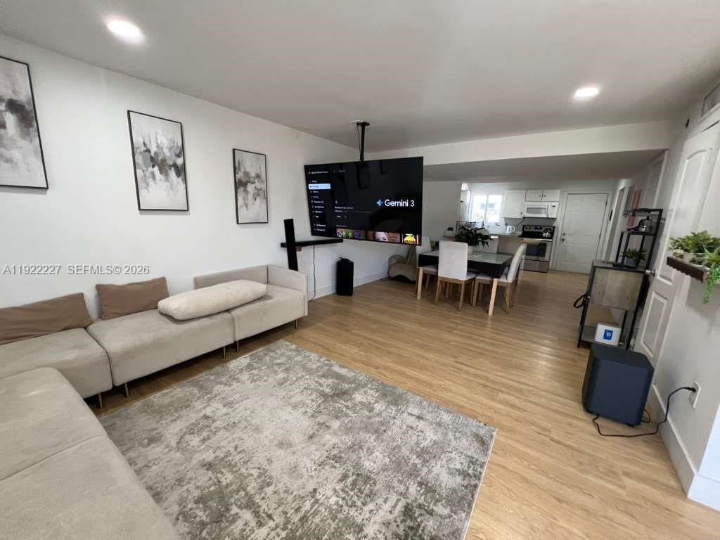 1480 Northeast 151st Street, Unit 101 Miami, FL 33162 - Photo 5 of 26 a living room with furniture and a flat screen tv