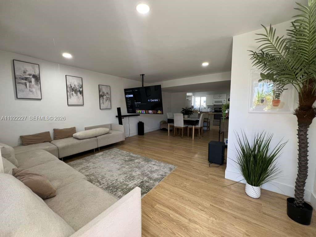 1480 Northeast 151st Street, Unit 101 Miami, FL 33162 - Photo 6 of 26 a living room with furniture potted plant and a table