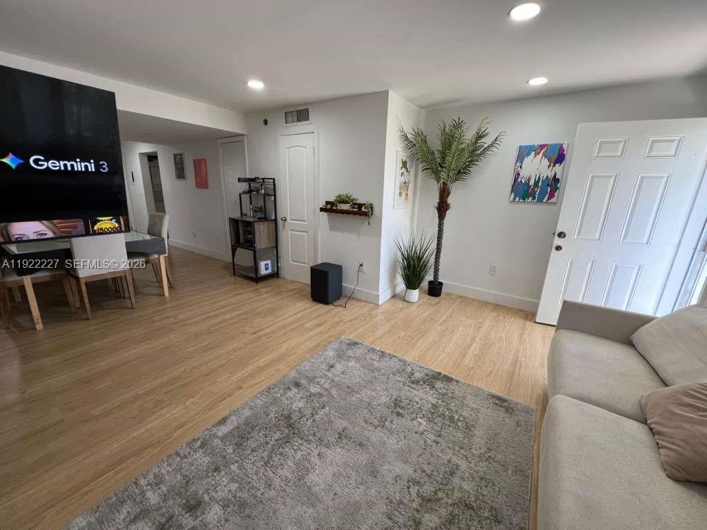 1480 Northeast 151st Street, Unit 101 Miami, FL 33162 - Photo 7 of 26 a living room with furniture and a flat screen tv