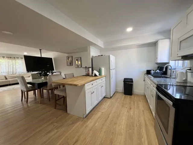 a large kitchen with a lot of counter space and wooden floor
