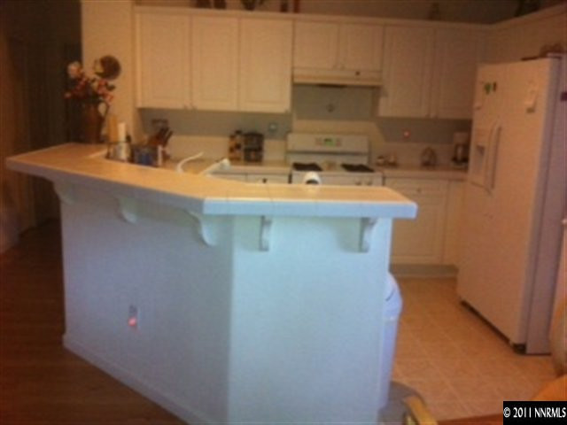 1708 Trek Trail Reno, NV 89521 - Photo 5 of 10 a kitchen with a sink a refrigerator and cabinets
