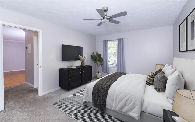 a spacious bedroom with a bed and a flat screen television