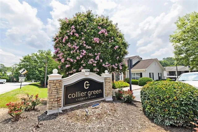 a sign board with a house in the background