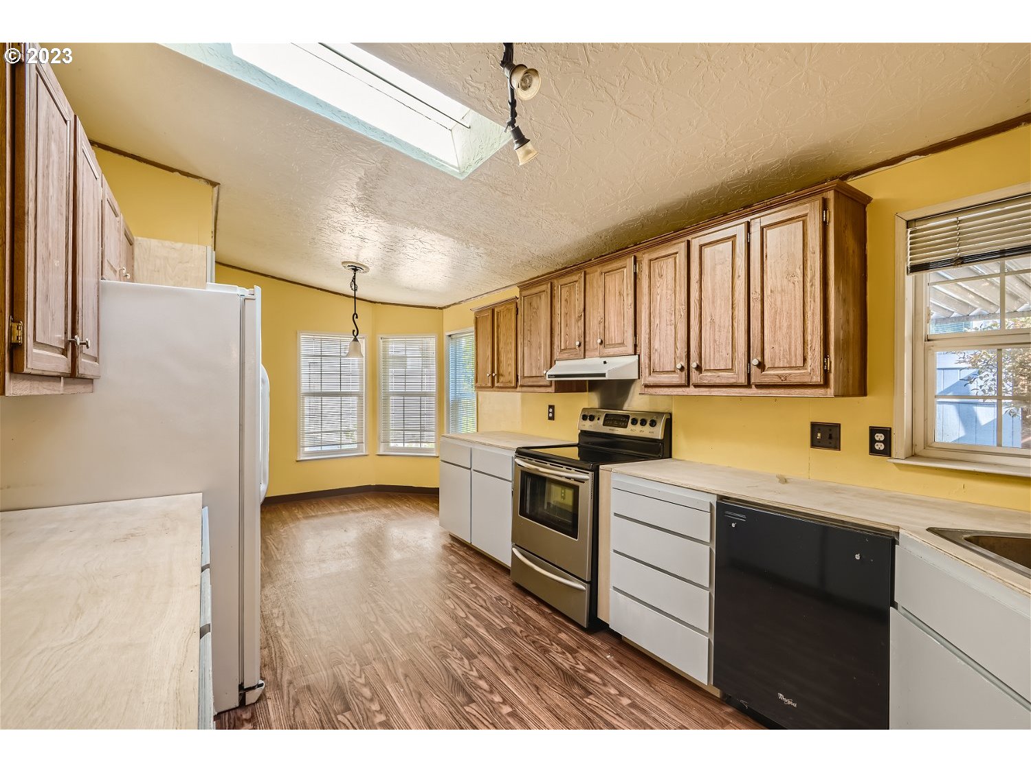 4239 Southeast 122nd Avenue, Unit 14 Portland, OR 97236 - Photo 5 of 11 a kitchen with stainless steel appliances granite countertop a sink a stove cabinets counter space and a window