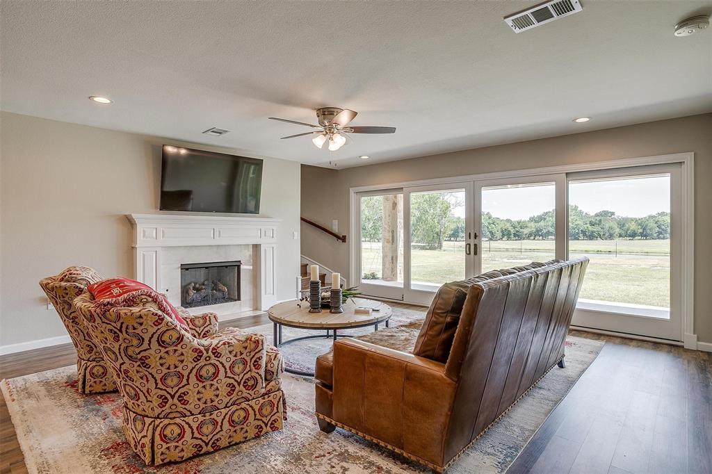 8650 South Fm 730 Boyd, TX 76023 - Photo 24 of 40 Living room with hardwood / wood-style flooring, a fireplace, a healthy amount of sunlight, and ceiling fan