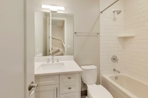 a bathroom with a sink toilet vanity and shower