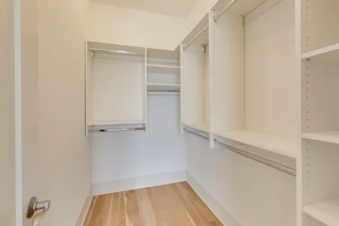 a view of walk in closet with empty racks