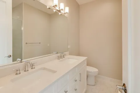 a bathroom with a toilet a sink and mirror