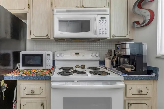 a kitchen with stainless steel appliances granite countertop white cabinets and a stove top oven