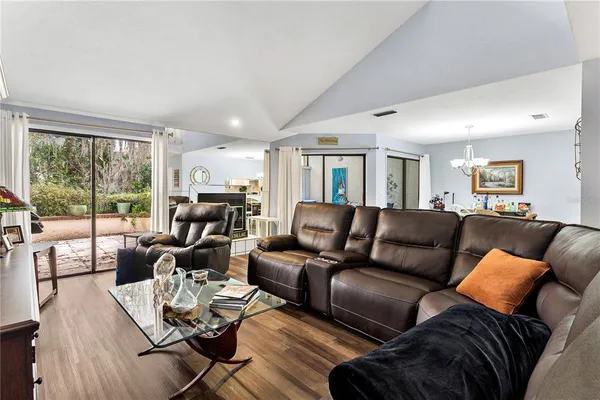 a living room with furniture and a flat screen tv with wooden floor