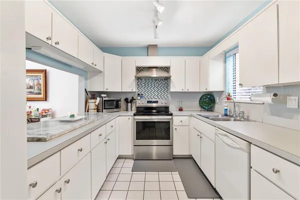 a kitchen with cabinets appliances a sink and a counter top space